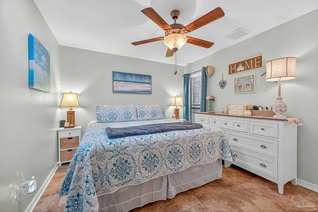 a bedroom with a bed and a flat tv screen on dresser