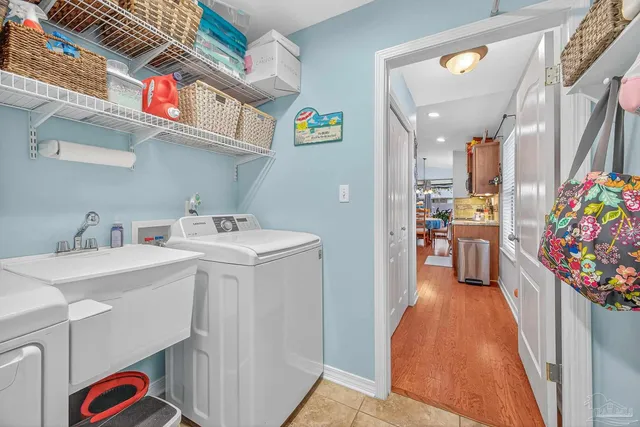 a living room with furniture kitchen view and a chandelier