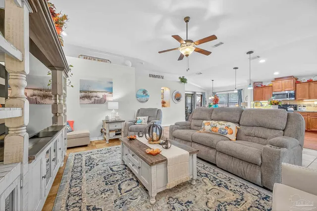 a room with stainless steel appliances kitchen island granite countertop a sink and a refrigerator