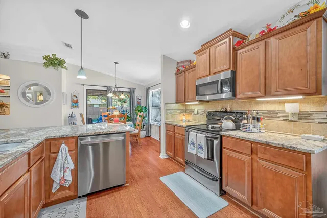 a dining room with furniture potted plants and wooden floor
