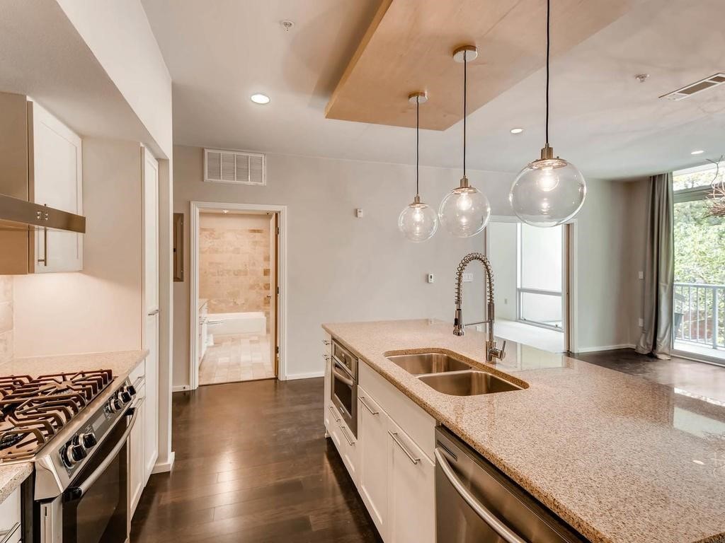 1600 Barton Springs Road, Unit 5208 Austin, TX 78704 - Photo 5 of 11 a kitchen with a sink stove and wooden floor
