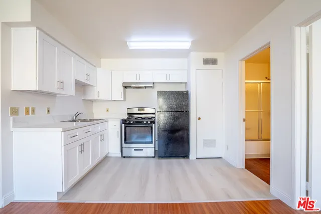 a kitchen with stainless steel appliances a stove a sink and a refrigerator