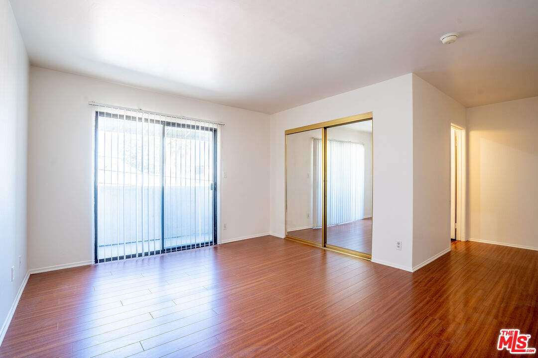 820 South St Andrews Place, Unit 304 Los Angeles, CA 90005 - Photo 13 of 16 an empty room with wooden floor and windows