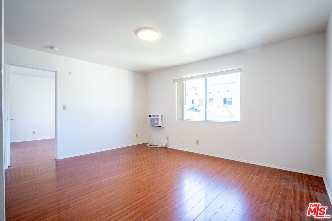 820 South St Andrews Place, Unit 304 Los Angeles, CA 90005 - Photo 4 of 16 an empty room with wooden floor and windows