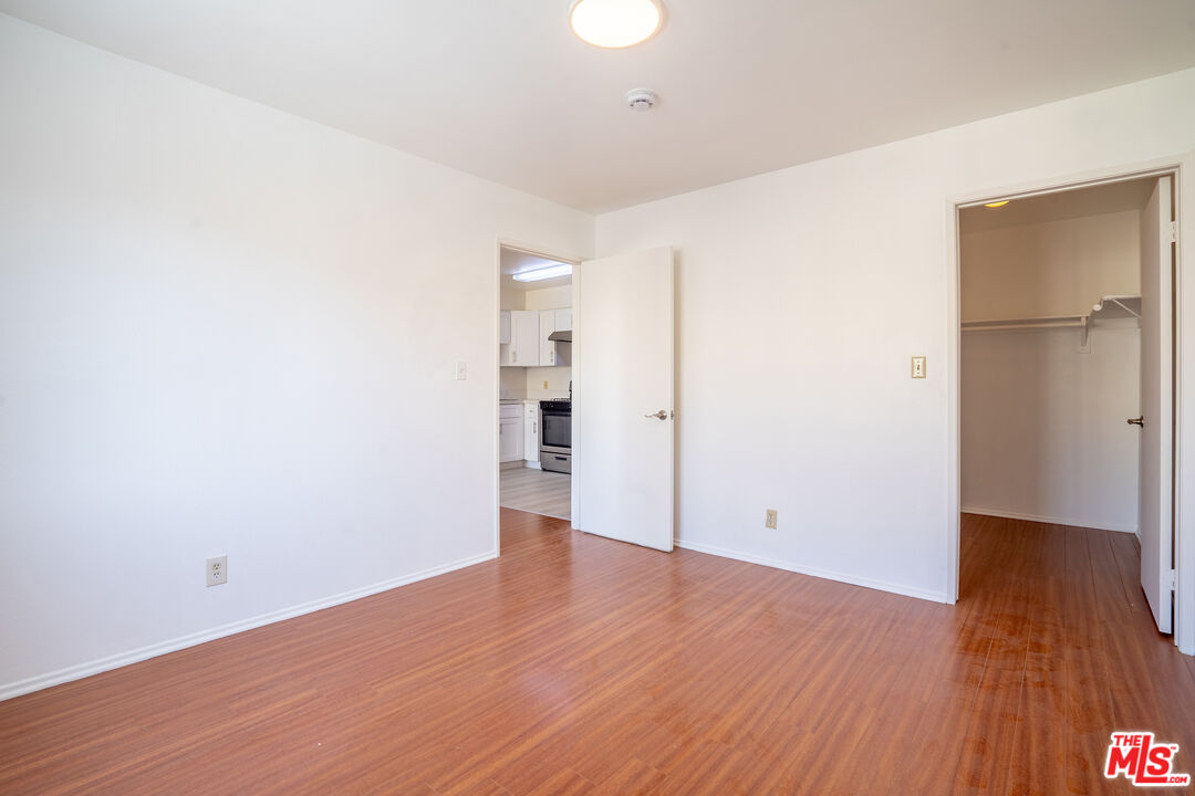 820 South St Andrews Place, Unit 304 Los Angeles, CA 90005 - Photo 7 of 16 an empty room with wooden floor