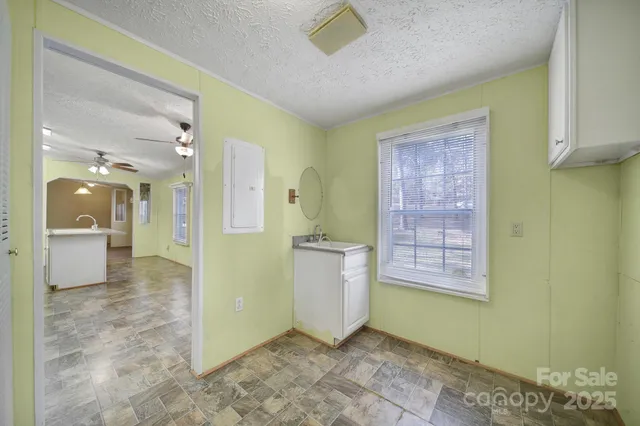 a view of a hallway with wooden floor and a bathroom