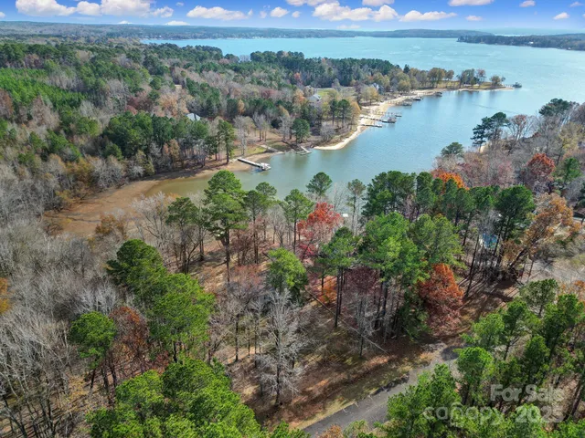 an aerial view of residential houses with outdoor space and lake view