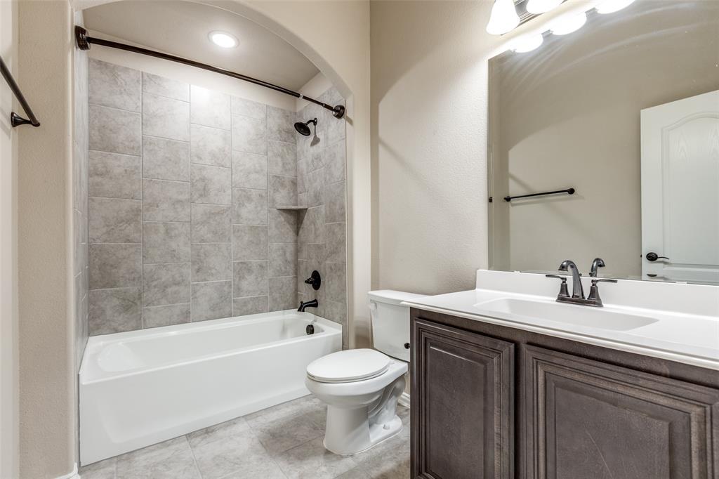 1605 George Lane Little Elm, TX 75068 - Photo 21 of 25 a bathroom with a sink a toilet and a mirror