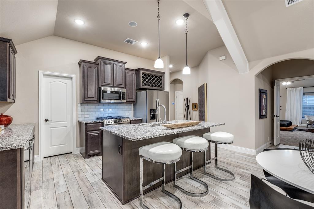 1605 George Lane Little Elm, TX 75068 - Photo 4 of 25 a kitchen with stainless steel appliances granite countertop a sink a stove and a wooden floors