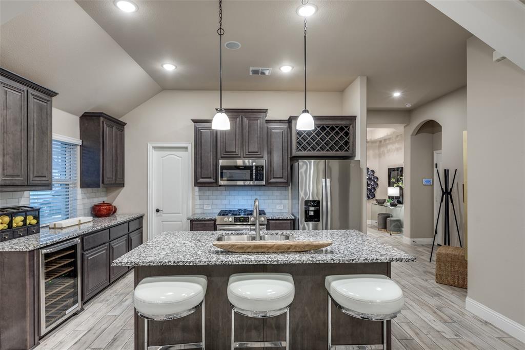 1605 George Lane Little Elm, TX 75068 - Photo 6 of 25 a kitchen with kitchen island granite countertop a sink and refrigerator