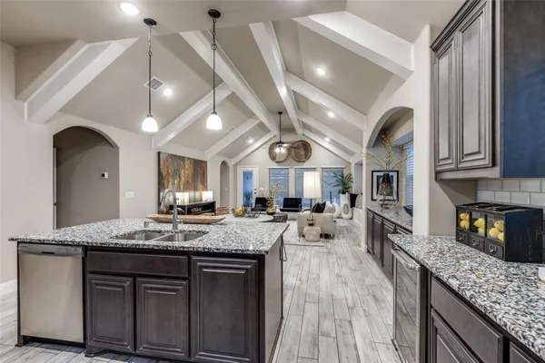 a large kitchen with granite countertop a sink counter space stainless steel appliances and cabinets