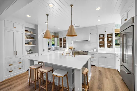 a kitchen with stainless steel appliances kitchen island granite countertop a kitchen island hardwood floor and a sink