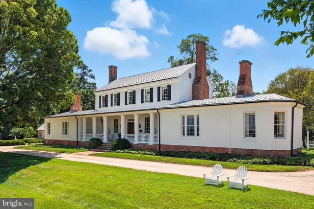 a front view of a house with a yard and potted plants