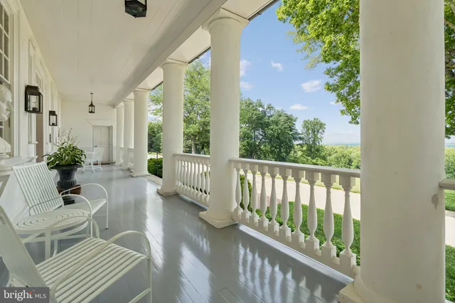 a dining room with furniture a chandelier and wooden floor