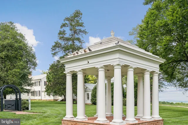 a front view of a house with a yard and potted plants