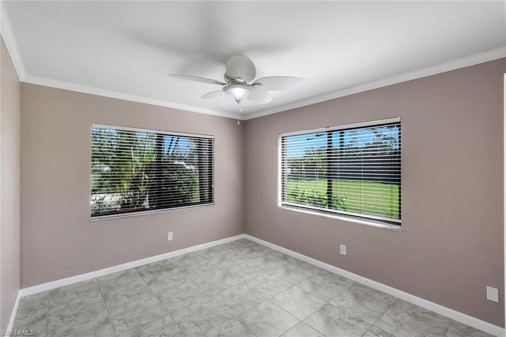 5857 Rattlesnake Hammock Road, Unit 101 Naples, FL 34113 - Photo 14 of 19 Spacious room featuring tile flooring, neutral wall tones, crown molding, and two windows equipped with blinds