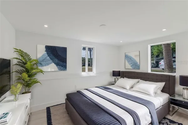 a bedroom with a bed and a potted plant