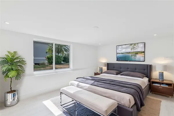 a bedroom with a bed and a potted plant