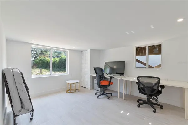 a view of a workspace with furniture and a window