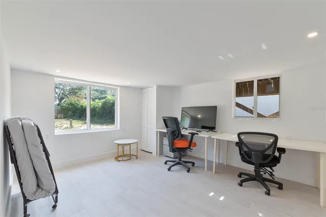 a view of a workspace with furniture and a window
