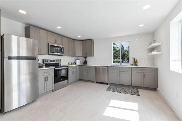 a kitchen with kitchen island a white cabinets and refrigerator