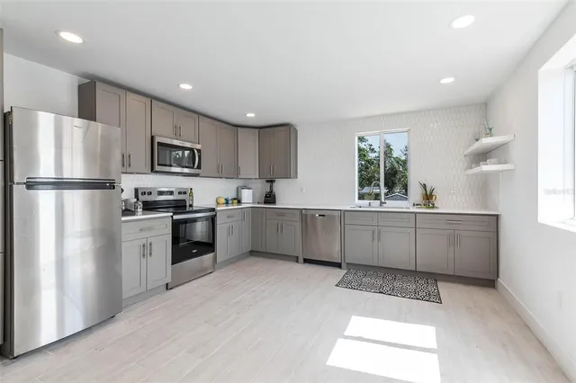 a kitchen with kitchen island a white cabinets and refrigerator