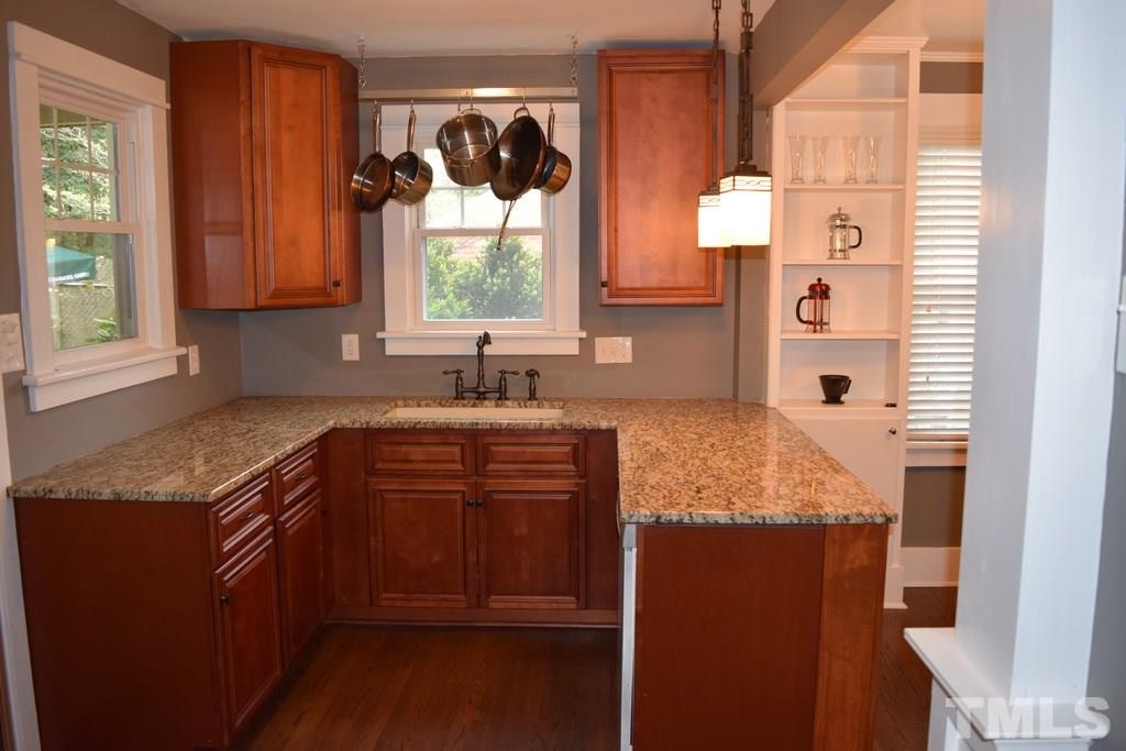 709 East Whitaker Mill Road Raleigh, NC 27608 - Photo 3 of 18 a kitchen with granite countertop a sink stove and cabinets