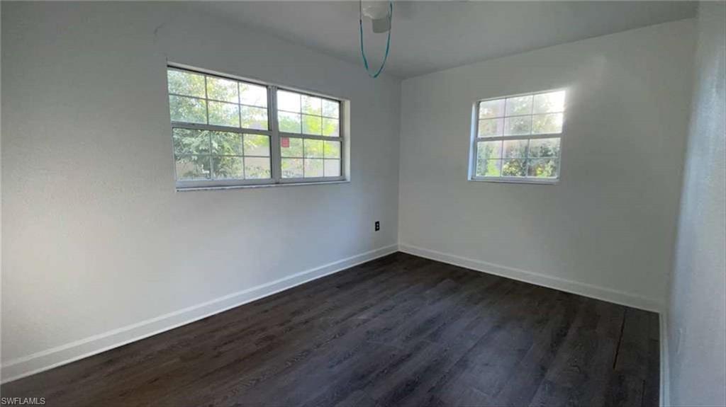 216 Maria Street Fort Myers, FL 33916 - Photo 7 of 19 an empty room with wooden floor and windows