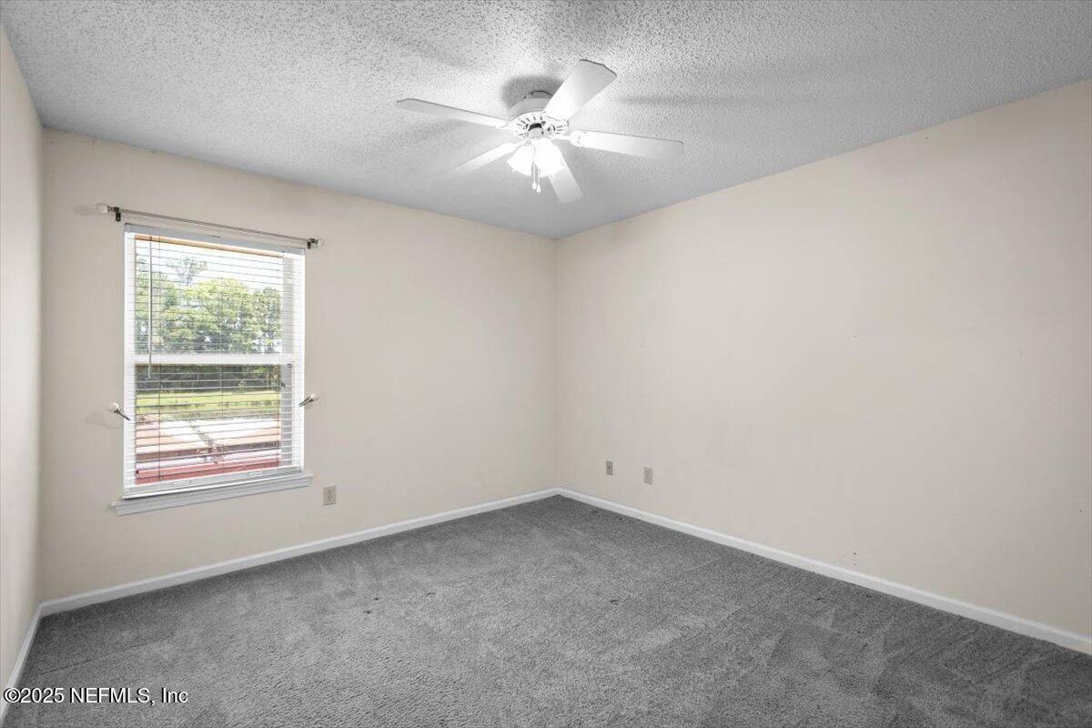 1385 Soaring Flight Way Jacksonville, FL 32225 - Photo 21 of 34 an empty room with a window and a fan