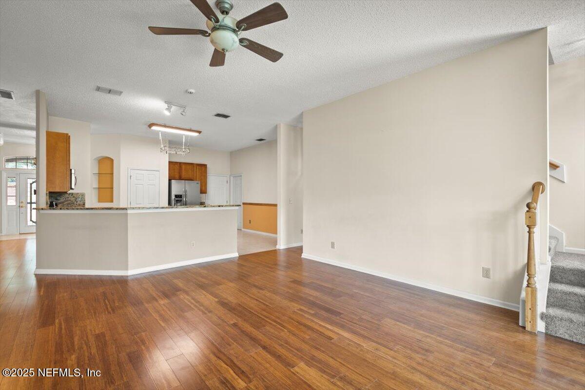 1385 Soaring Flight Way Jacksonville, FL 32225 - Photo 6 of 34 a view of a kitchen with wooden floor and a ceiling fan