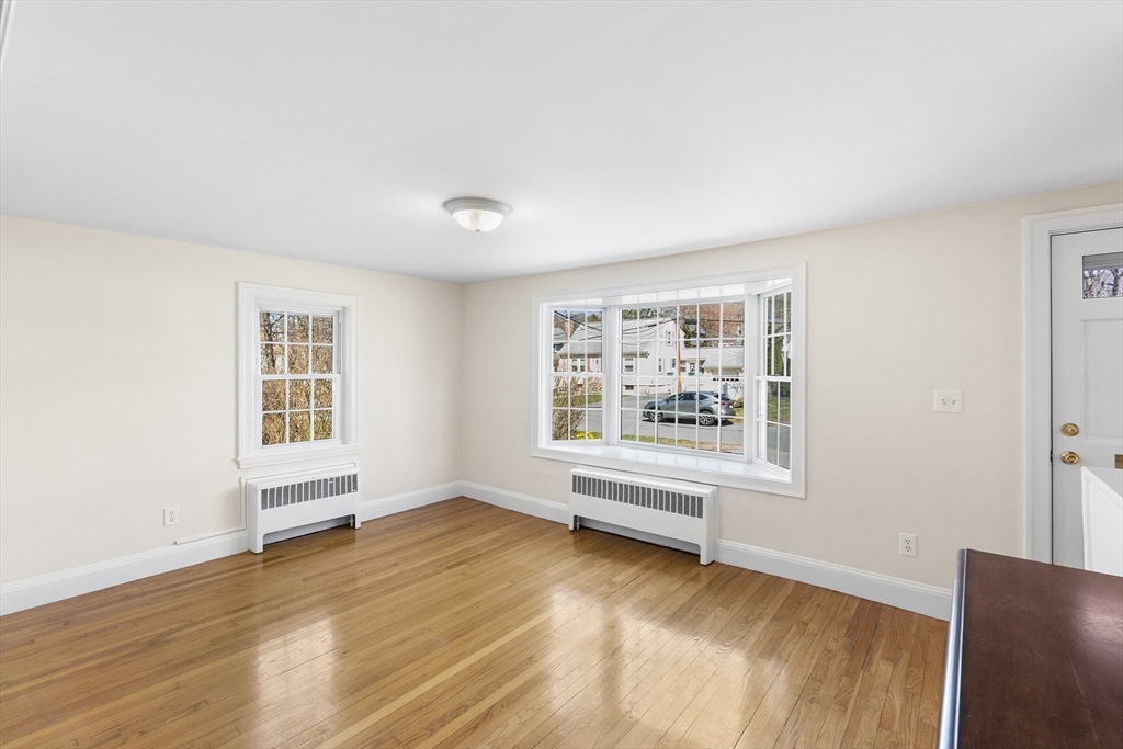 10 Ellison Road Lexington, MA 02421 - Photo 6 of 35 a view of an empty room with wooden floor and a window