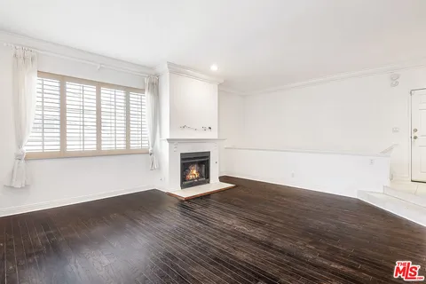 a view of empty room with wooden floor and fireplace