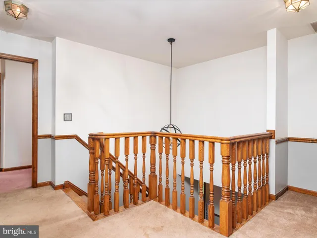 a view of staircase with railing and a chandelier