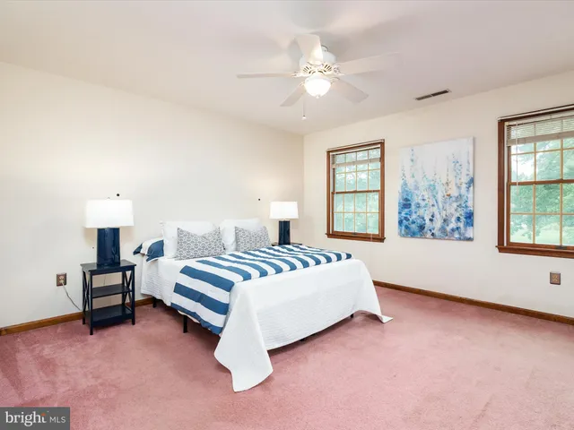 a spacious bedroom with a bed and a large window