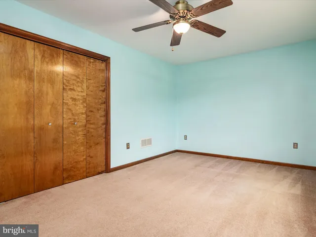 an empty room with a window and a fan