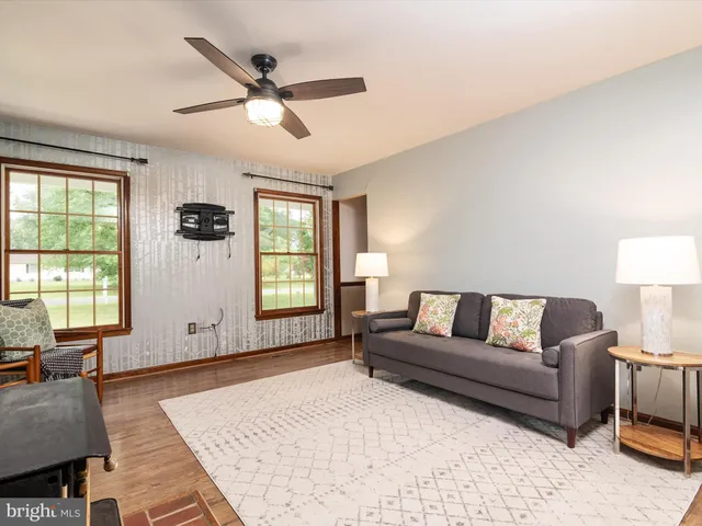 a living room with furniture and windows with wooden floor