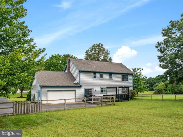 a view of a house with a yard deck and a small cabin