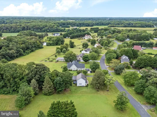 an aerial view of residential houses with outdoor space and trees