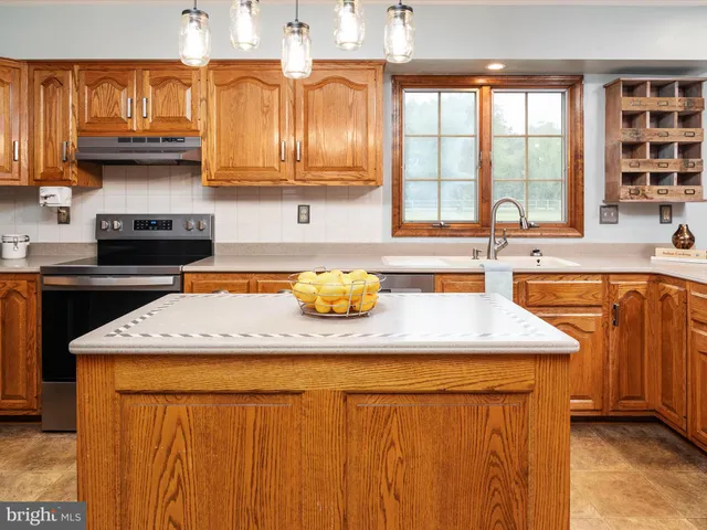 a kitchen with stainless steel appliances granite countertop a sink a stove and cabinets