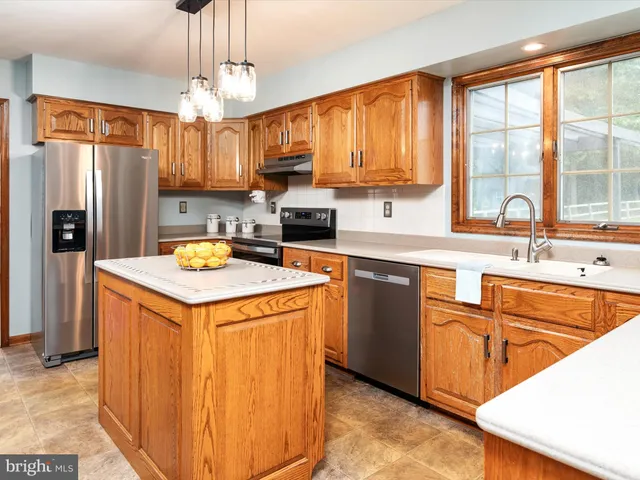 a kitchen with stainless steel appliances granite countertop a sink a stove and refrigerator