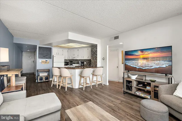 a kitchen with stainless steel appliances kitchen island granite countertop a table and chairs in it