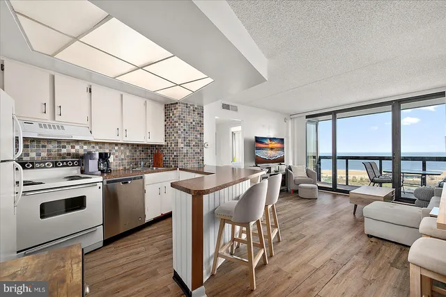 a kitchen with a dining table chairs and wooden floor