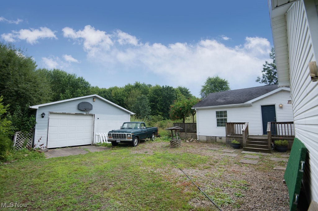 4594 Center Road Andover, OH 44003 - Photo 35 of 39 View of green lawn featuring a detached garage, an outdoor structure, and driveway