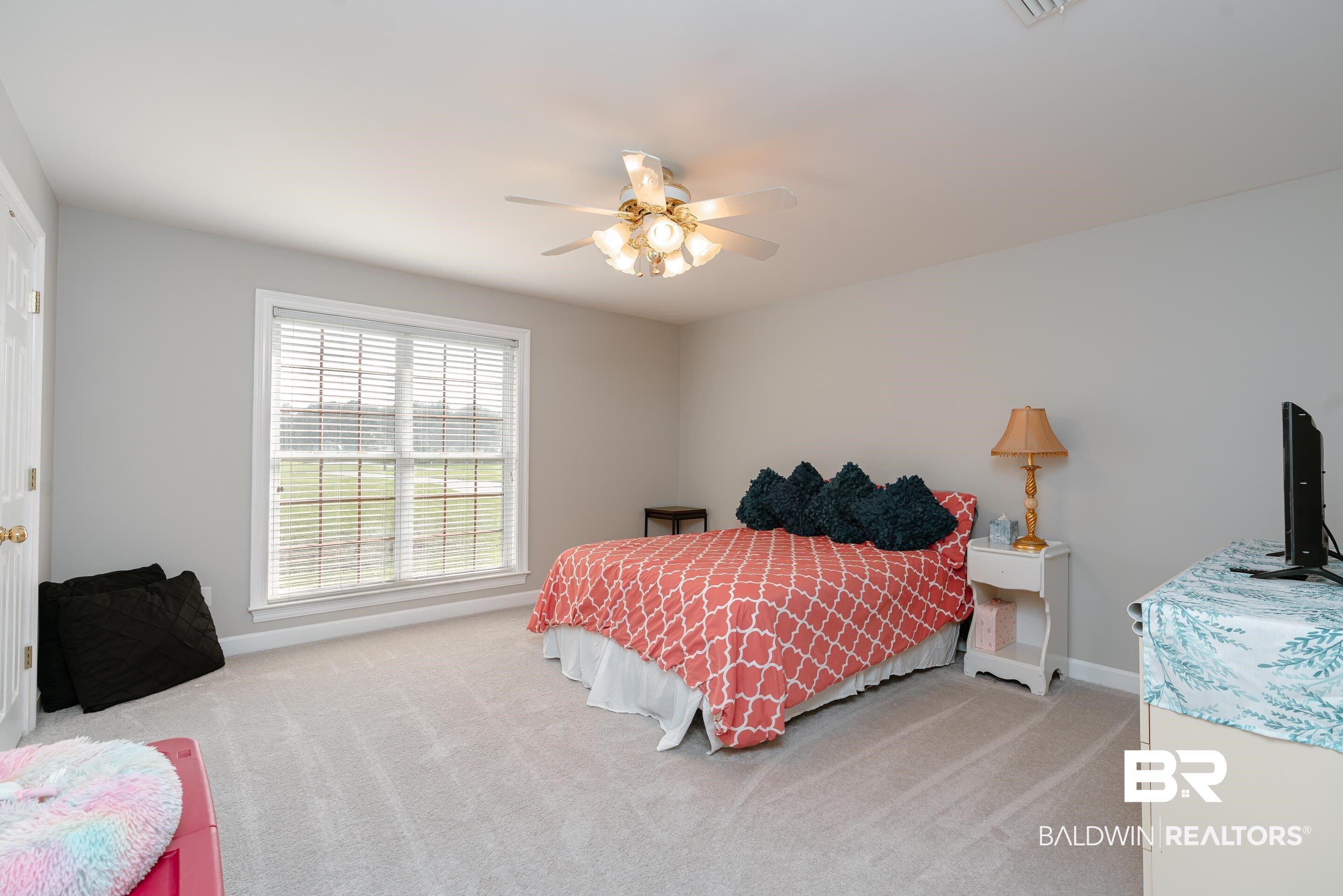 9477 Deerfield Drive Irvington, AL 36544 - Photo 26 of 58 Bedroom featuring ceiling fan, light carpet, and multiple windows