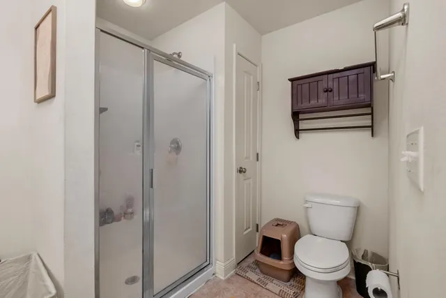 a bathroom with a toilet and a shower