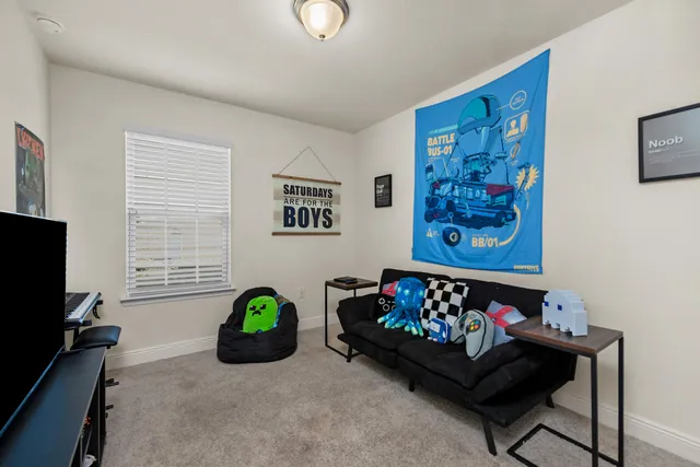 a living room with couch a baby crib and a window
