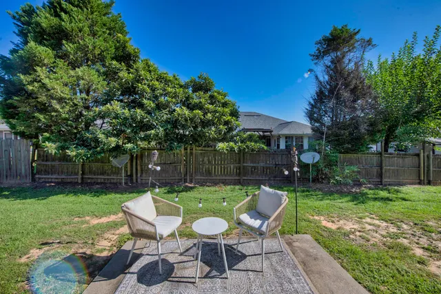 a view of a chair and table in backyard of the house