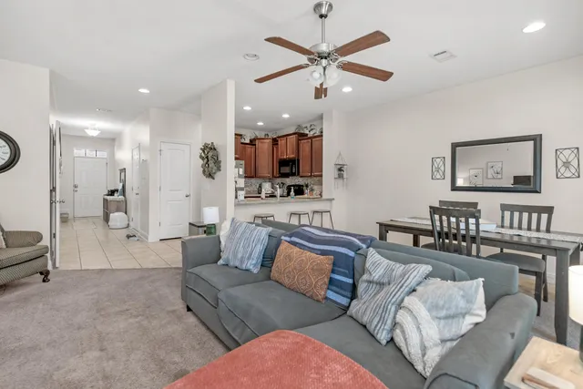 a living room with furniture and a view of kitchen
