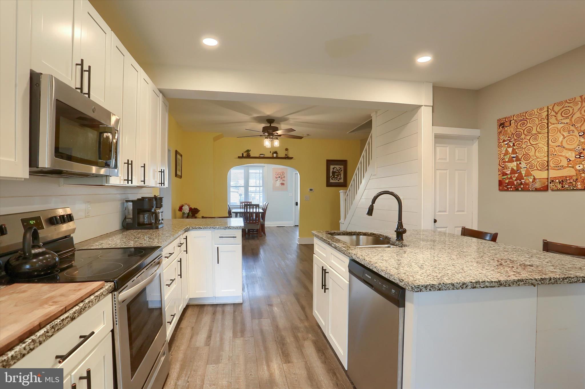 1544 Lafayette Street Lebanon, PA 17042 - Photo 14 of 49 a kitchen with stainless steel appliances granite countertop a stove top oven a sink dishwasher a dining table and chairs with wooden floor