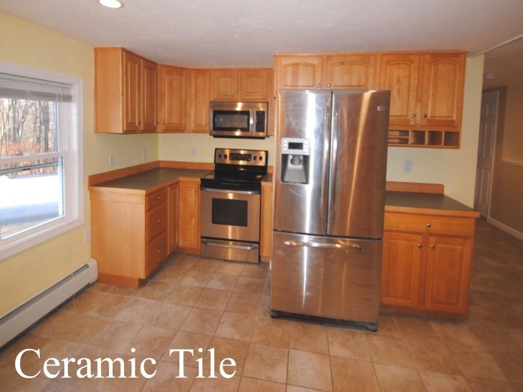 16 Hartness Road, Unit B Sutton, MA 01590 - Photo 1 of 16 a kitchen with granite countertop a refrigerator and a stove